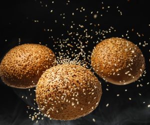 Flying,Burger,Buns,With,Sesame,Seeds,On,Black,Background,With